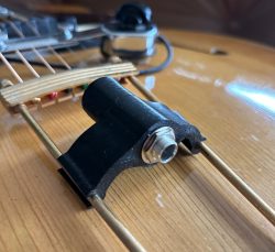 Archtop trapeze tailpiece-mounted output jack